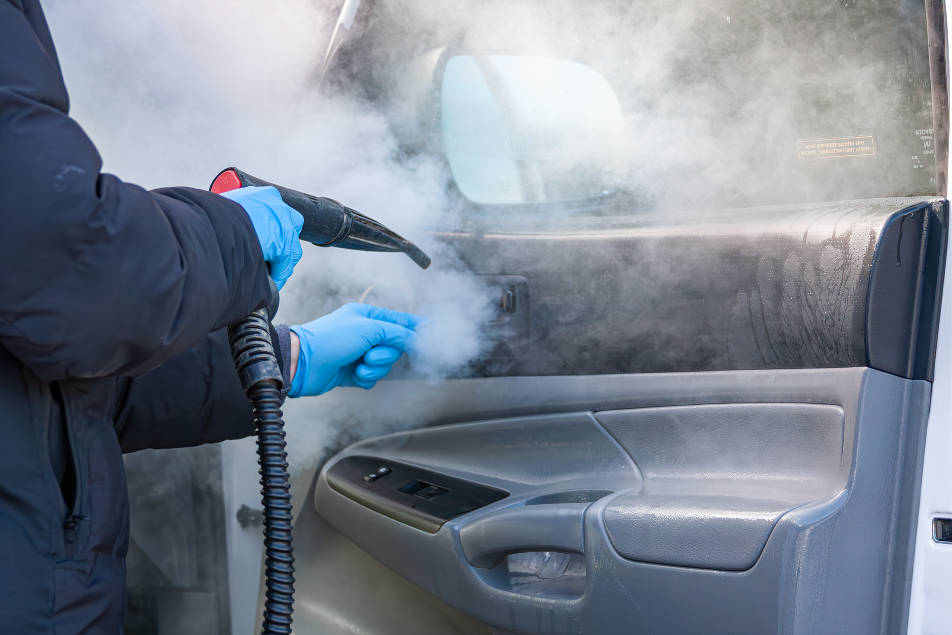 detailer using a steamer on a cars interior door handle during a mobile detail in bremerton, wa